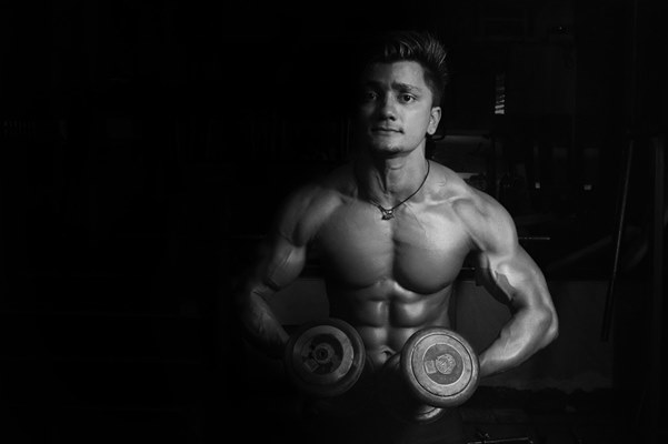 Grayscale photo of a man holding pair-of dumbbells